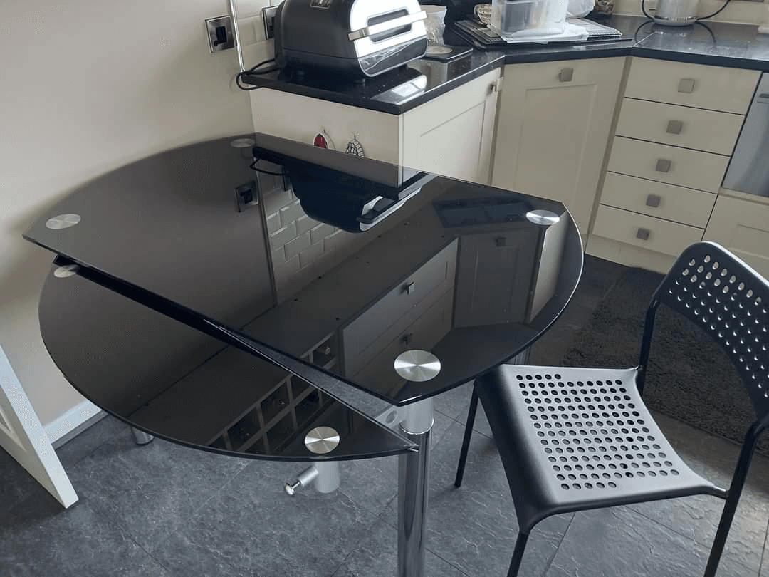 La table de cuisine en verre épais s'ouvre de chaque côté pour
s'agrandir. - Photo 1
